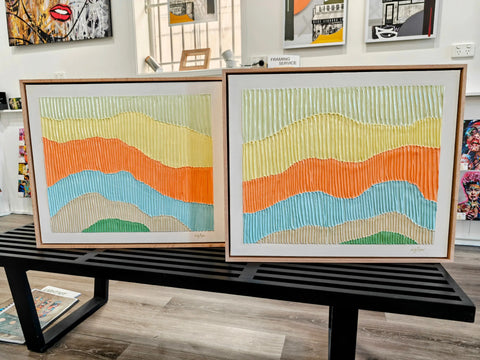 Two framed, textured, abstract landscape paintings.