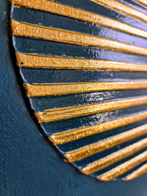 Decorative fan-like object with alternating gold and navy blue ridged segments.