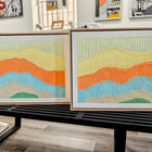 Two framed, textured, abstract landscape paintings.