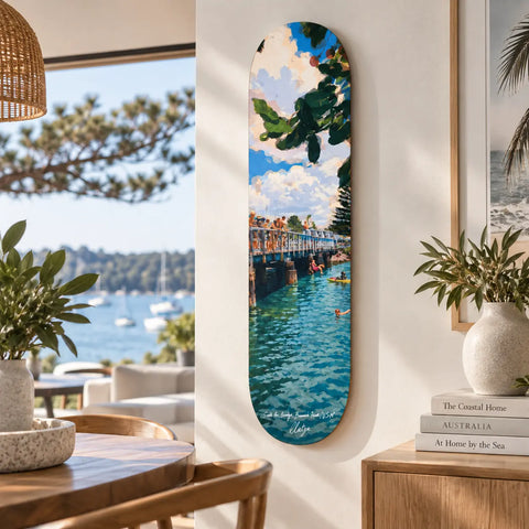 A vertically oriented skateboard deck painted with people swimming under a bright sky brunswick heads Australia keepsake fakeboard