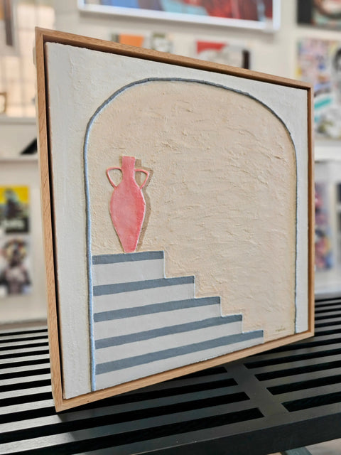 Framed painting of a vase on stairs.