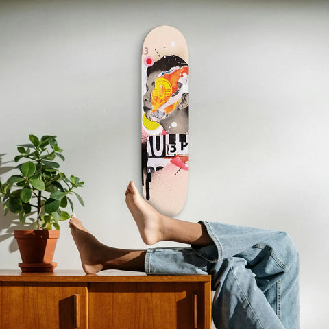 Skateboard deck with colorful graffiti-style artwork displayed against a wall.