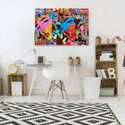 Vibrant pop art canvas featuring colorful graffiti-style artwork with abstract faces and text.