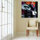 A chair in a room with a painting on the wall