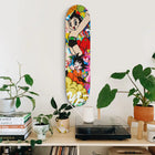 Colorful skateboard deck with anime-style cartoon characters mounted on a wall.