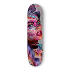 Skateboard deck featuring vibrant pop art-style graffiti artwork with pink and purple tones.