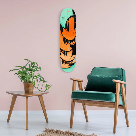 Skateboard deck with vibrant orange and teal abstract design mounted on a wall.