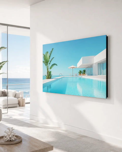 A sleek aluminium wall art titled by the pool showing a vibrant infinity pool and ocean view on a modern wall-mounted tv