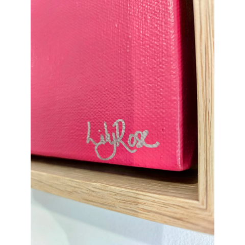 Pink canvas or painting with a silver signature in the corner.